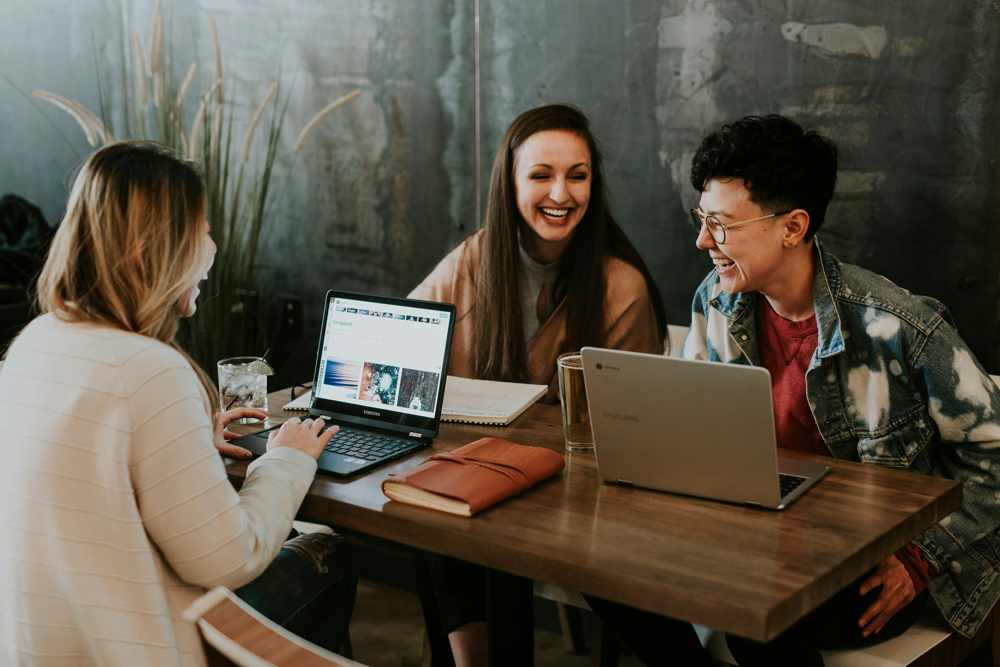 Modern e-learning programs often incorporate collaborative projects and peer interaction, simulating real internship teamwork. (Image: A group of interns or students collaborating on an AI prompt design task.)