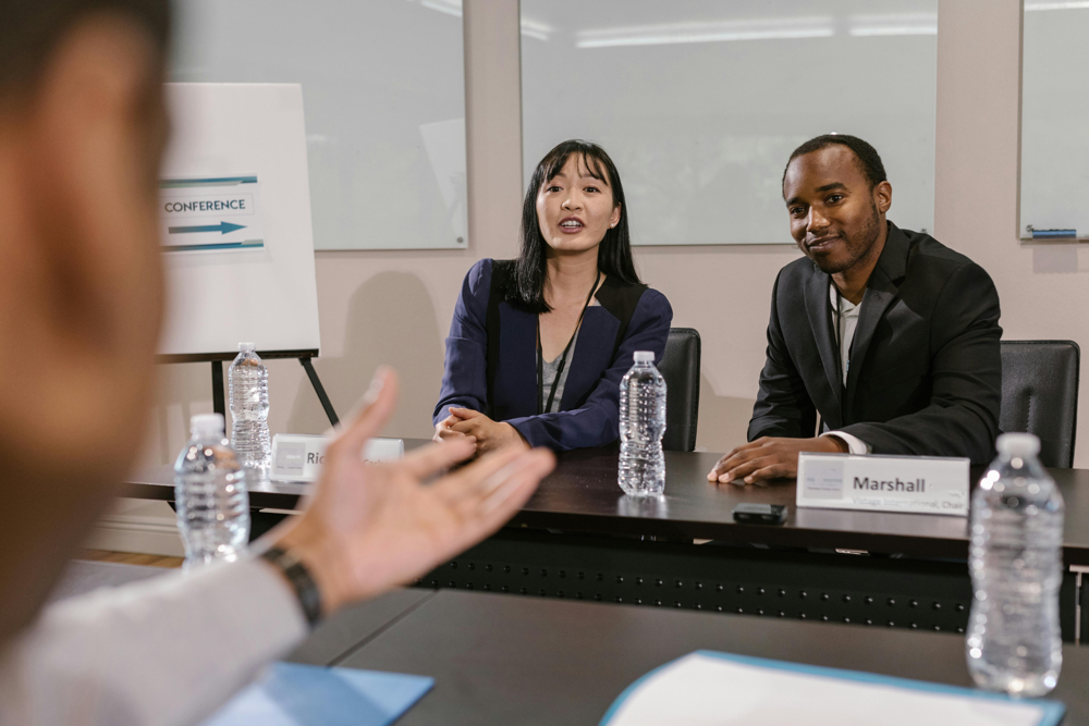 Two interviewers engage with a candidate in a technical discussion – a scene that mirrors the collaborative nature of a system design interview. Machine Learning System Design Interviews often feel like a conversation. You and the interviewer are essentially brainstorming a solution together. Embrace that dynamic; it’s okay to ask, “What do you think about this approach?” or to adjust your design when given hints. It shows flexibility and teamwork, which are great qualities to demonstrate.
